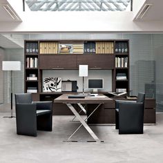 an office with desk, chairs and bookshelf in it's center area