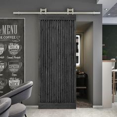 a chalkboard menu hangs on the wall next to a gray chair in front of a sliding door