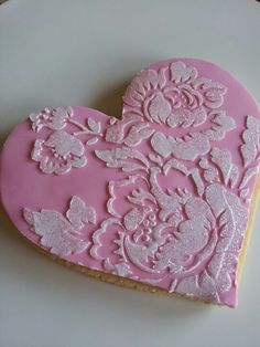 a pink heart shaped cookie on a white plate