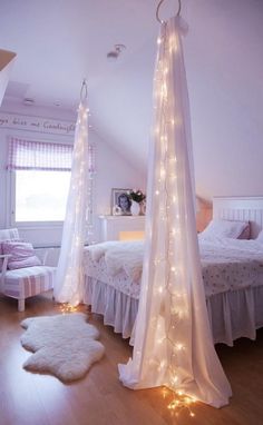 a bedroom with white bedding and lights on the ceiling