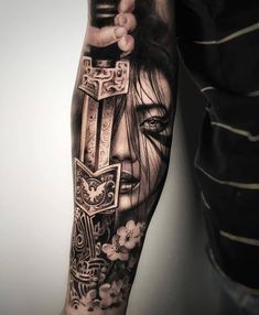 a man's arm with tattoos on it and an image of a woman holding a cross