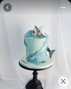 there is a cake that looks like a fish in the water on top of a plate