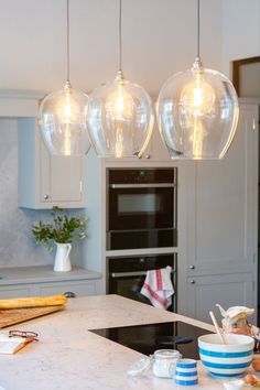 three lights hanging from the ceiling in a kitchen