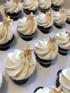 cupcakes with white frosting and gold star decorations