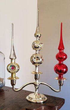 three glass candlesticks sitting on top of a wooden table