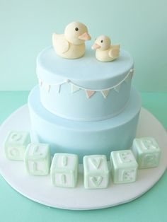 there is a cake with two ducks on top and blocks spelling out the word love