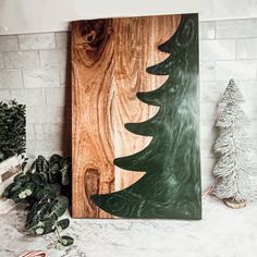 a wooden christmas tree is displayed on a shelf next to other holiday decorations and greenery