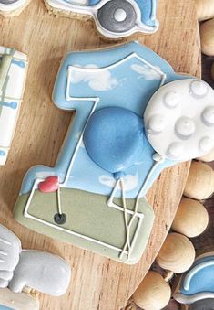 decorated cookies are arranged in the shape of golf balls and tees on a wooden board