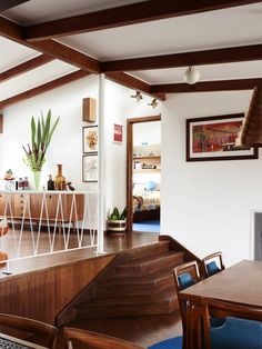 a living room filled with furniture and a fire place next to a dining room table