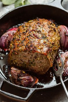 a steak in a skillet with onions on the side