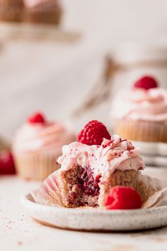 a close up of a plate of cupcakes with raspberry frosting