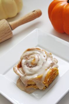 there is a piece of cake with icing on it and an orange next to it