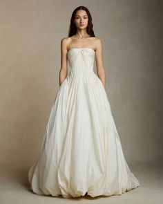 a woman in a white wedding dress posing for the camera