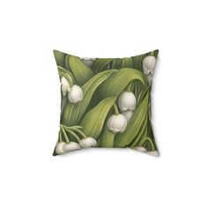 a green pillow with white flowers on it