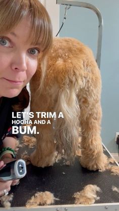 a woman holding a cell phone next to a dog on a table with hair all over it