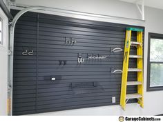 a yellow ladder is in front of a garage door with hooks on it and other tools hanging from the wall