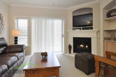 a living room filled with furniture and a flat screen tv mounted on the wall above a fireplace