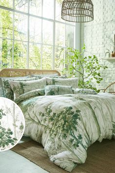 an image of a bedroom setting with green plants on the comforter and bedding