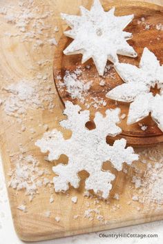 some snowflakes are sitting on a wooden cutting board