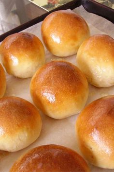 six rolls sitting on top of a pan covered in wax paper next to each other