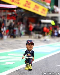 a little boy is standing on the race track