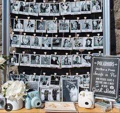 a table topped with pictures and flowers next to a stone wall