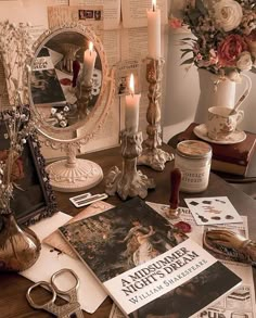 a table topped with lots of books and candles