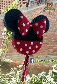 a minnie mouse pinata hanging from the side of a brick building with white polka dots on it