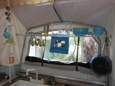 the inside of a tent with pots and pans hanging from it's ceiling