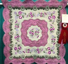 a purple and white quilted square with flowers in the center on a black background