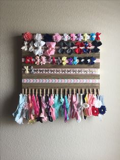 a wall hanging made out of old clothes pegs and ties with ribbons attached to it