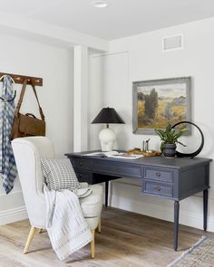 a desk with a chair, lamp and pictures on the wall