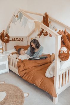 a woman and child laying in bed with stuffed animals