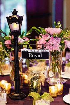 a table topped with lots of plates and vases filled with flowers