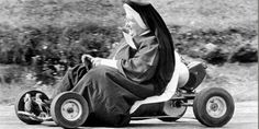 a nun riding on the back of a four wheeled vehicle