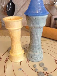 two clay towers sitting on top of a table next to a knife and other items