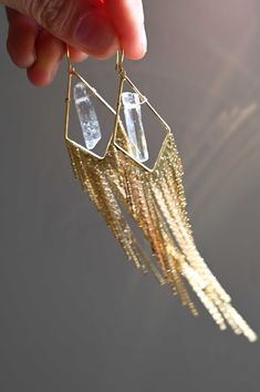 A spin-off of our most-loved fringe earrings, these Big Vision Quartz Earrings are the gold sophisticated earrings you've been looking for! These are perfect for a night out, a little black dress or as a gift to someone who loves Quartz crystal. You'll be turning heads with these babies on! Quartz is an amplifier of energy and intentions that enhances clarity and focus. Polished Quartz crystals Gold plated wire & fringe earrings Weight: 1/4 oz Drop length: 4.5" Handmade in Arizona We try to matc Crystal Stick Earrings, Metal Jewelry Handmade, Unique Wedding Earrings, Angel Aura Quartz Necklaces, Sophisticated Earrings, Crystal Quartz Earrings, Quartz Crystal Jewelry, Formal Jewelry, A Little Black Dress