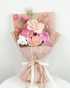 a bouquet of flowers wrapped in pink paper