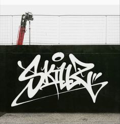 a man riding a skateboard down the side of a wall covered in graffitti