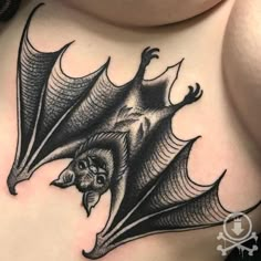 a woman's stomach with a bat tattoo on it