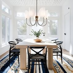 a dining room table with chairs and a potted plant