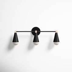 three black and white lights mounted on a wall