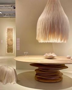 an unusual light fixture hanging over a table with white hair on it's head