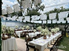 an outdoor dining area with tables and chairs set up for a formal function in the garden