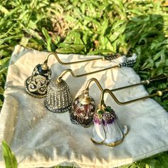 three earrings are sitting on a towel in the grass