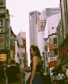 a woman standing in the middle of a busy city street