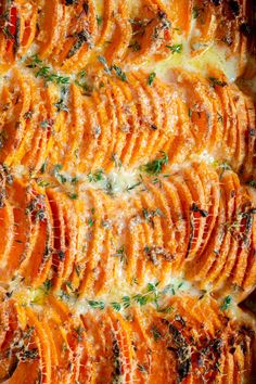 an orange casserole with cheese and herbs on top