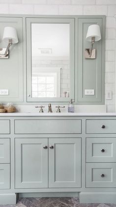 a bathroom with double sinks and two mirrors