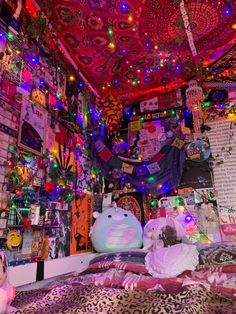 a bed room filled with lots of stuffed animals and lights hanging from the ceiling above it