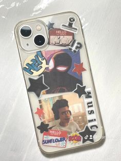 a cell phone case with stickers and pictures on the back, sitting on a white surface